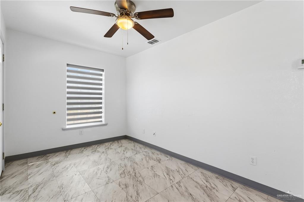 109 Ash Street, Unit B Donna, TX 78537 - Photo 7 of 14 an empty room with windows and fan