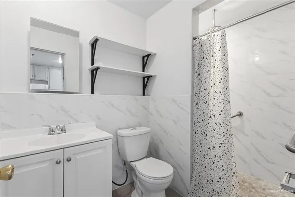 a bathroom with a sink a toilet and shower