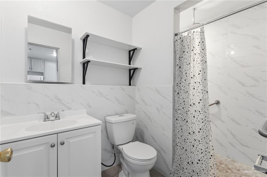 109 Ash Street, Unit B Donna, TX 78537 - Photo 10 of 14 a bathroom with a sink a toilet and shower
