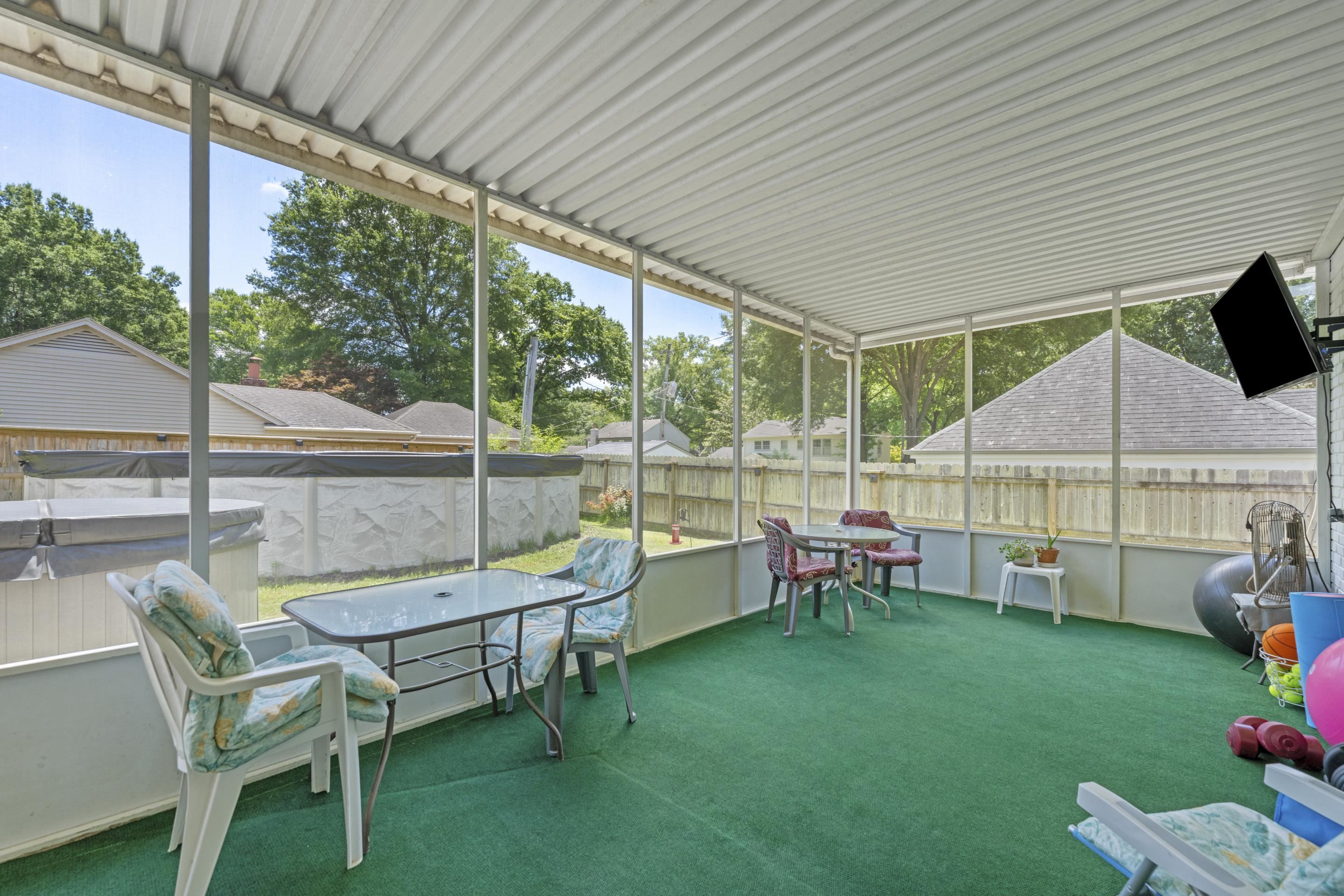 2218 Riverdale Road Germantown, TN 38138 - Photo 32 of 40 Enjoy outdoor living year-round in this large screened sunroom featuring plenty of space for lounging, dining, and entertaining while staying protected from the elements.