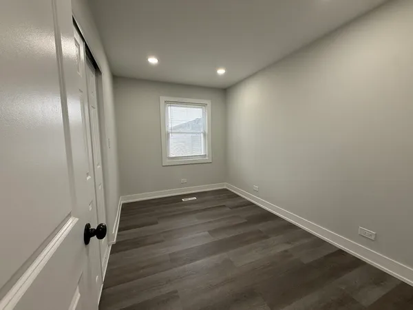 an empty room with wooden floor and sliding door
