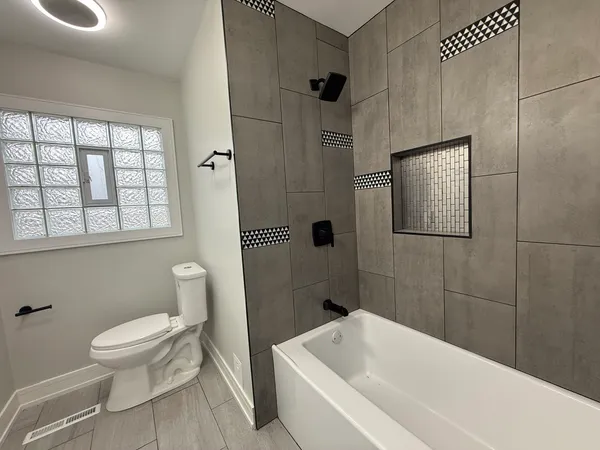 a white toilet sitting next to a bath tub