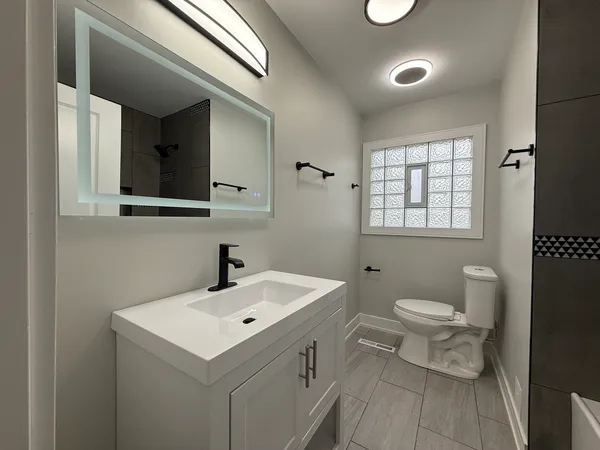 a bathroom with a sink a toilet and shower