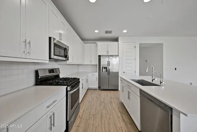 a kitchen with stainless steel appliances granite countertop a sink stove and refrigerator