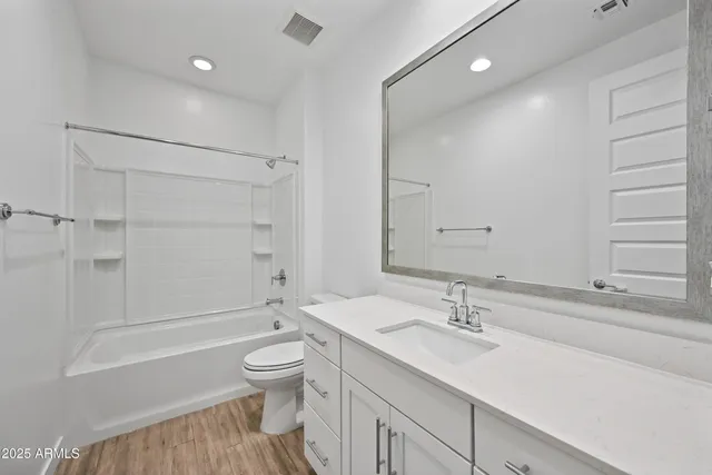 a bathroom with a sink a toilet and a large mirror