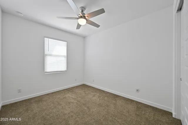 an empty room with a window and a fan