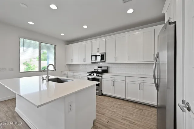 a kitchen that has a sink cabinets counter space and appliances
