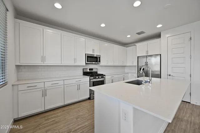 a kitchen with white cabinets and stainless steel appliances