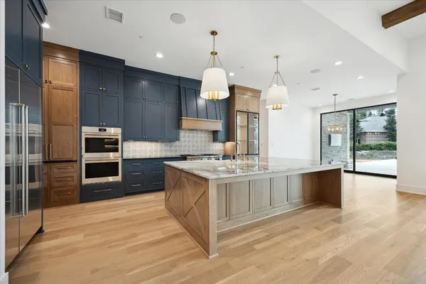 a large kitchen with stainless steel appliances granite countertop a stove and cabinets