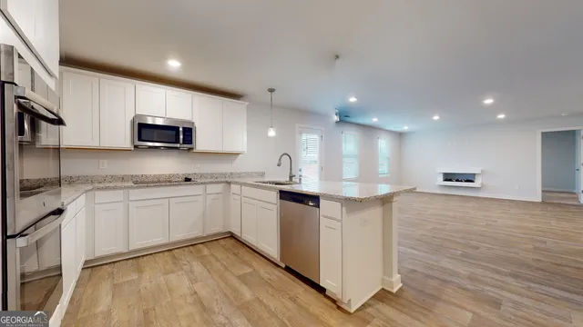 a kitchen with stainless steel appliances granite countertop a sink a stove a microwave and a refrigerator