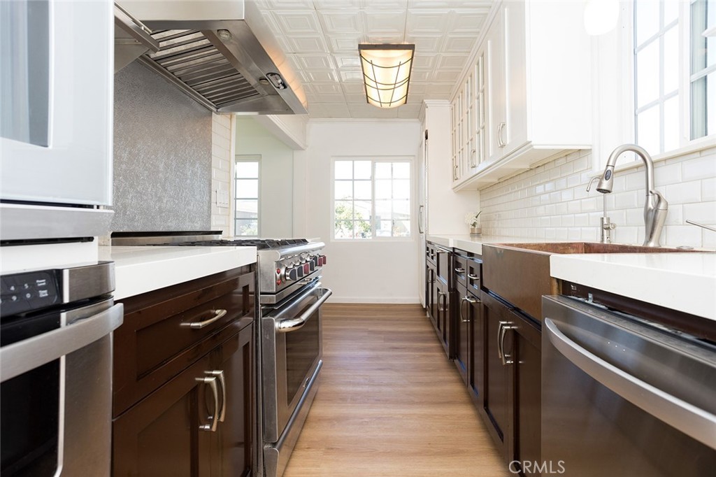 1118 East Joel Street Carson, CA 90745 - Photo 11 of 35 a kitchen with stainless steel appliances a sink stove and cabinets