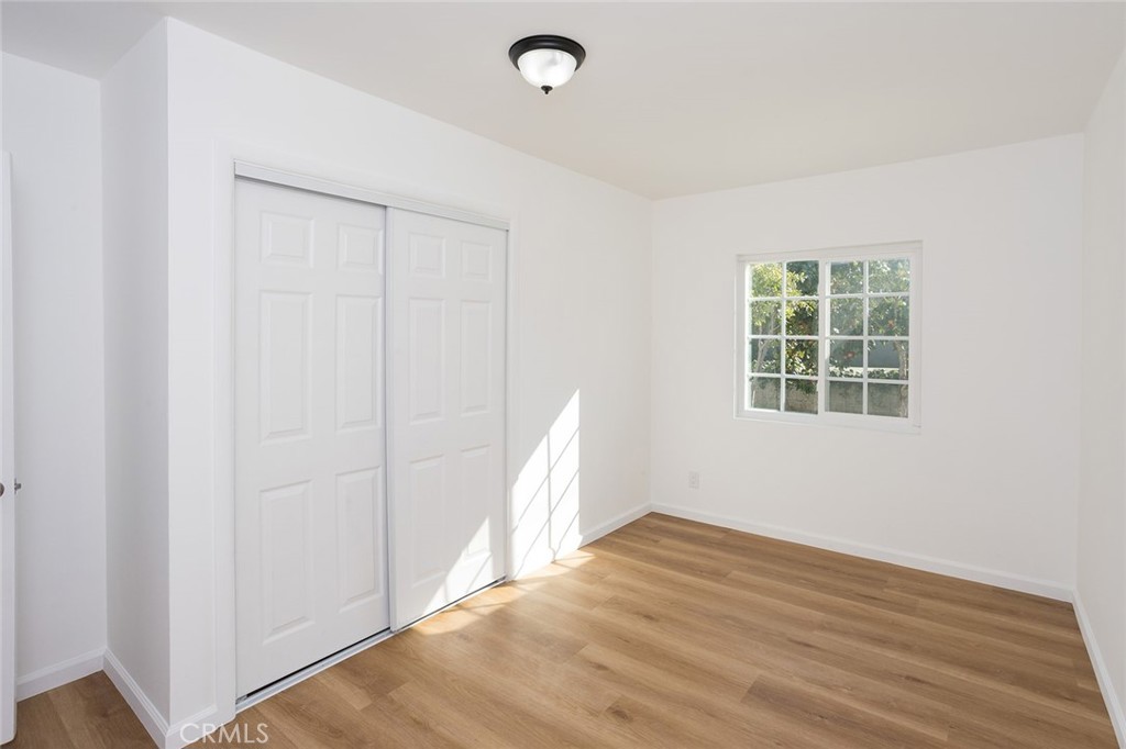 1118 East Joel Street Carson, CA 90745 - Photo 22 of 35 an empty room with wooden floor and windows