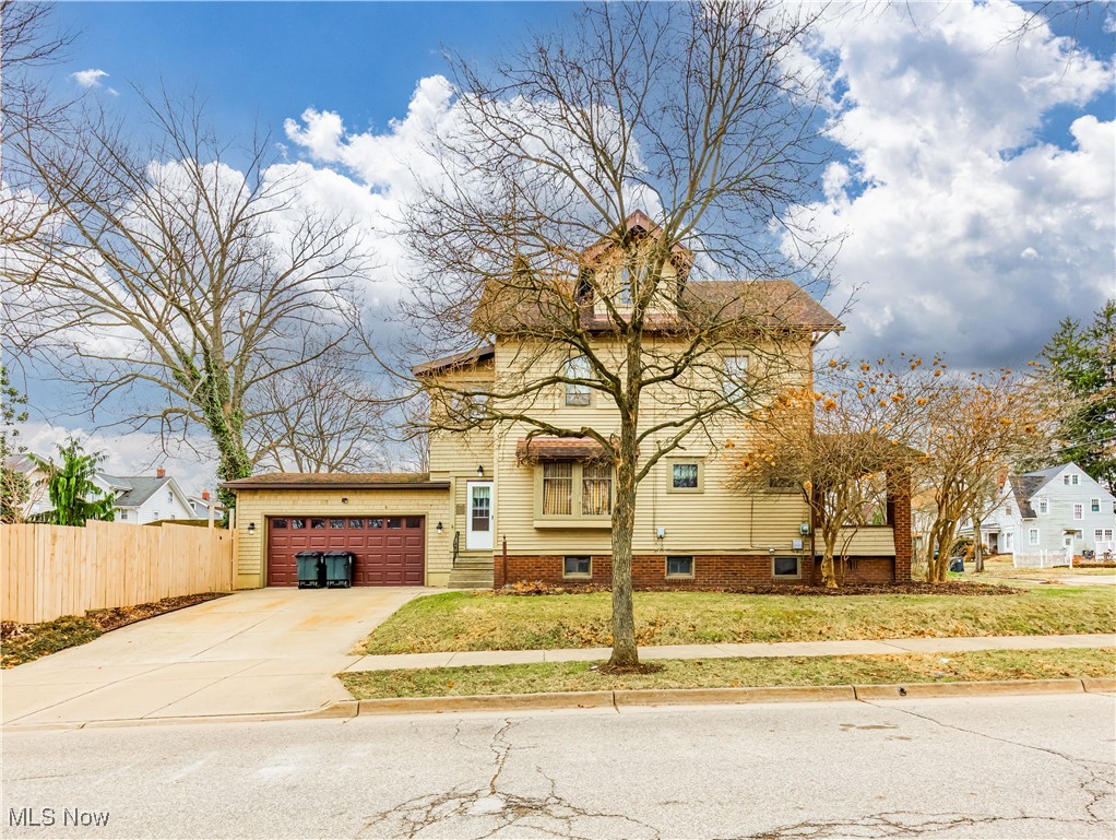 1095 Chalker Street Akron, OH 44310 - Photo 2 of 19 View of front facade featuring a front lawn, concrete driveway, a garage, and fence