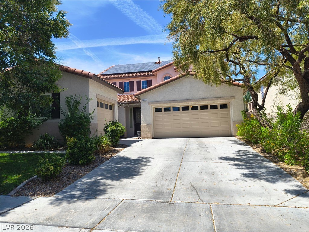 A terracotta-tiled roof and solar panels enhance this charming stucco residence.