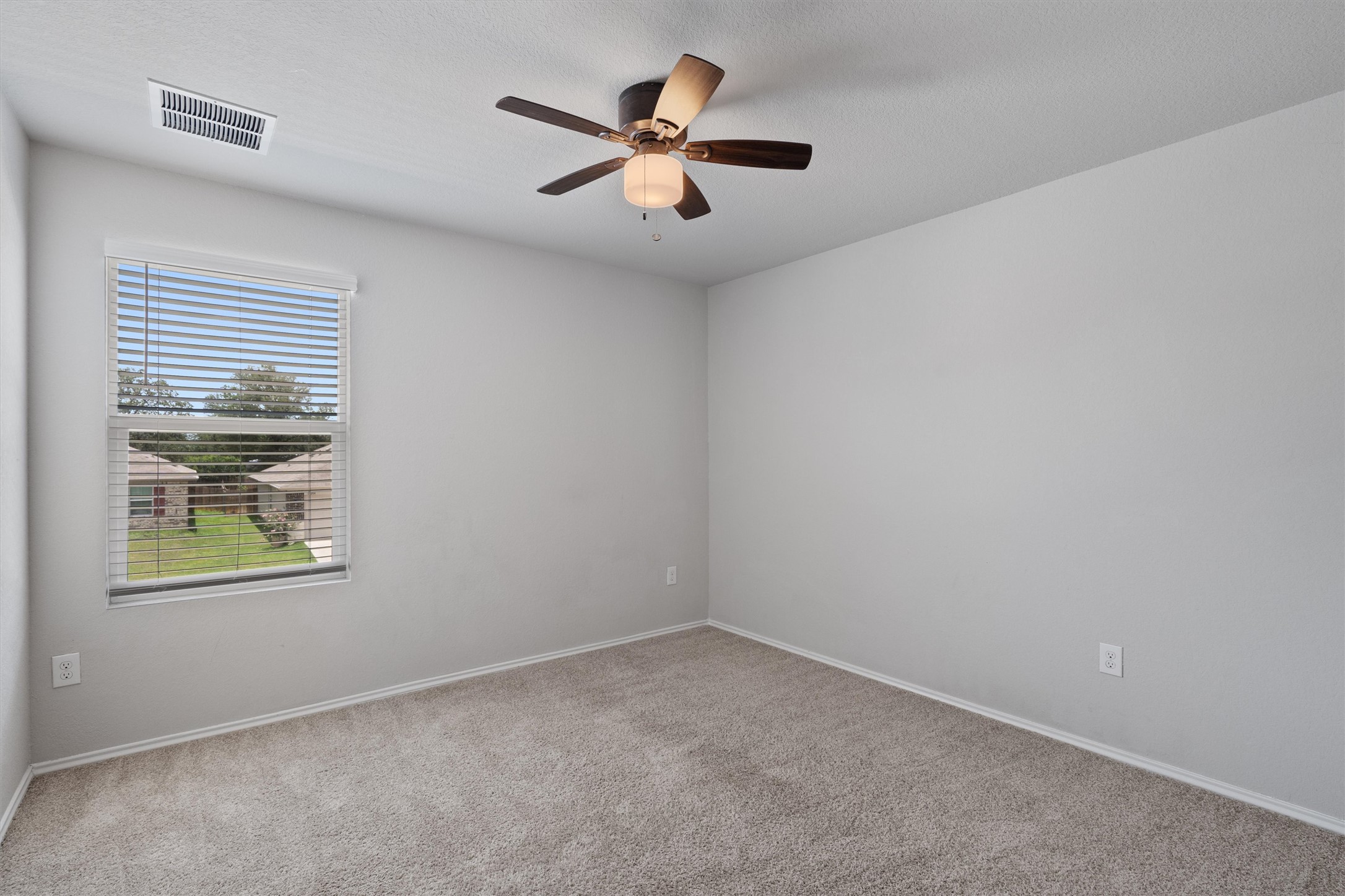 6121 Ronee Leah Drive Austin, TX 78724 - Photo 23 of 30 A well-lit bedroom space, providing comfortable accommodations with plush carpet and a window for natural illumination.