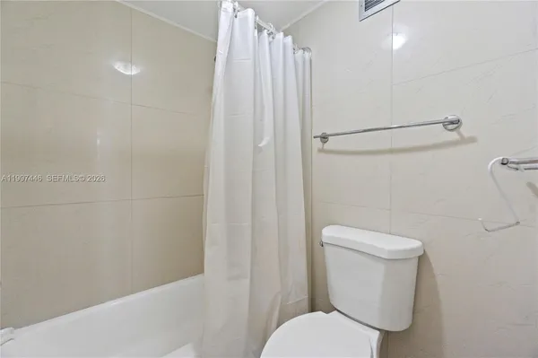 a white toilet sitting next to a shower
