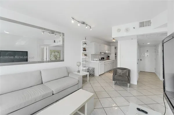 a living room with furniture and a kitchen area