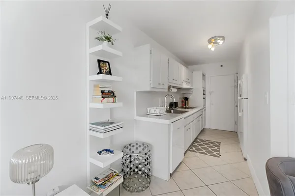 a kitchen with stainless steel appliances granite countertop a sink a stove a refrigerator and cabinets