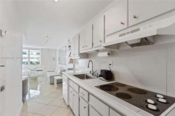 a kitchen with granite countertop a sink stove and cabinets