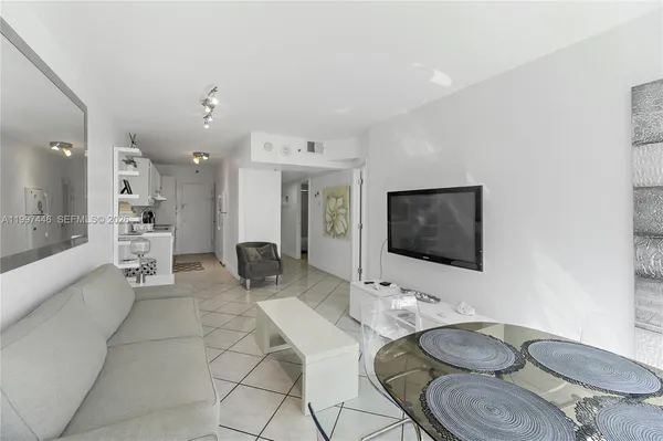 a living room with furniture a flat screen tv and kitchen view