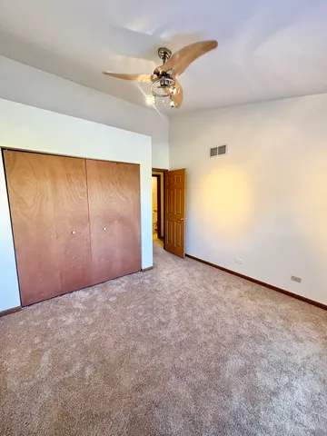 an empty room with a ceiling fan and closet