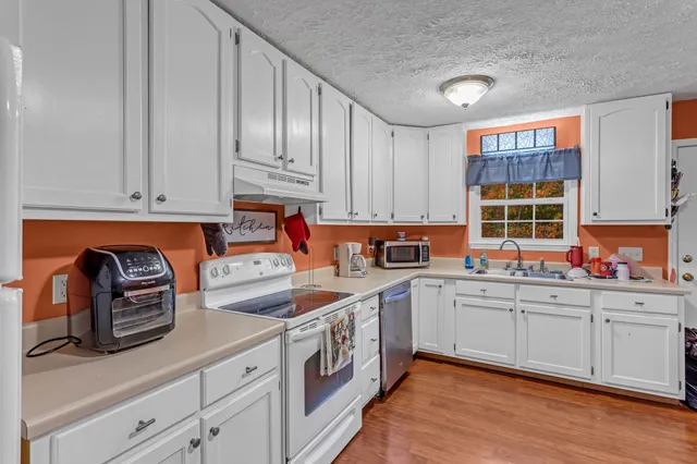 a kitchen with stainless steel appliances granite countertop a sink and cabinets