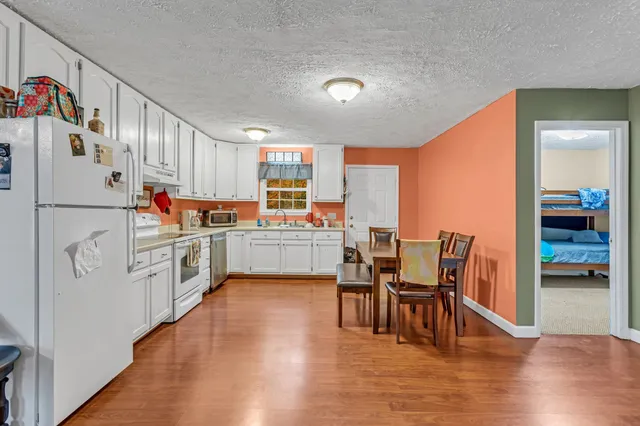 a kitchen with a table chairs refrigerator and cabinets