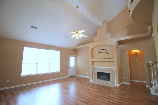 wooden floor fireplace and windows in an empty room