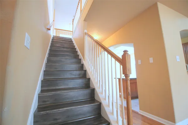 a view of a hallway with wooden floor and entryway