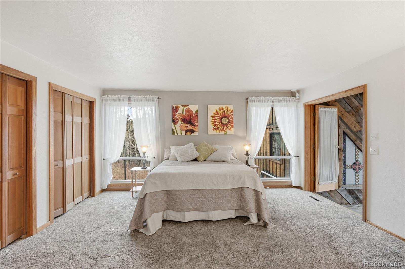13082 South Wamblee Valley Road Conifer, CO 80433 - Photo 13 of 35 a bedroom with a bed and a large window