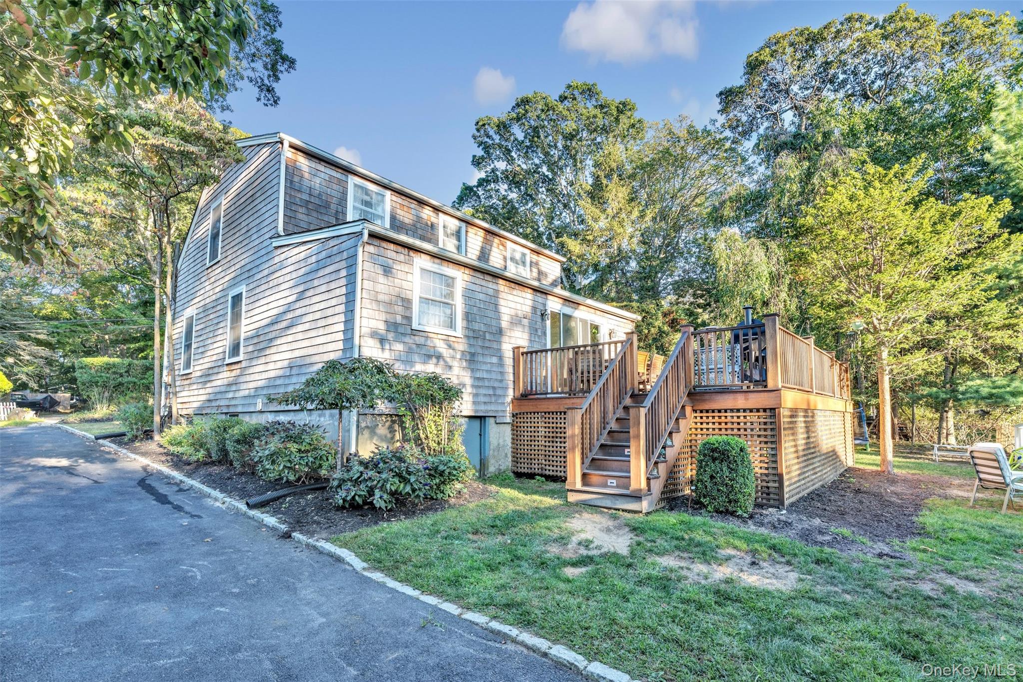 81 Beach Road Wading River, NY 11792 - Photo 12 of 25 Rear view of property with stairs, a deck, a lawn, and view of scattered trees