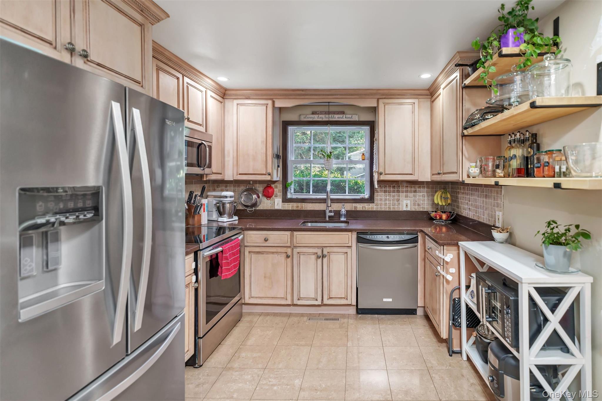 81 Beach Road Wading River, NY 11792 - Photo 2 of 25 Kitchen featuring appliances with stainless steel finishes, decorative backsplash, light tile patterned floors, light brown cabinetry, and recessed lighting