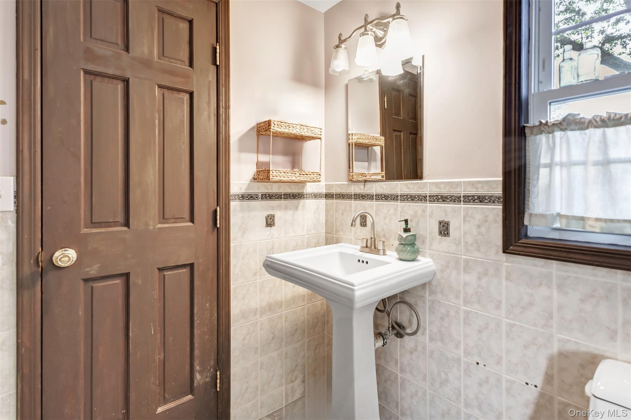 81 Beach Road Wading River, NY 11792 - Photo 9 of 25 Bathroom featuring tile walls and a wainscoted wall