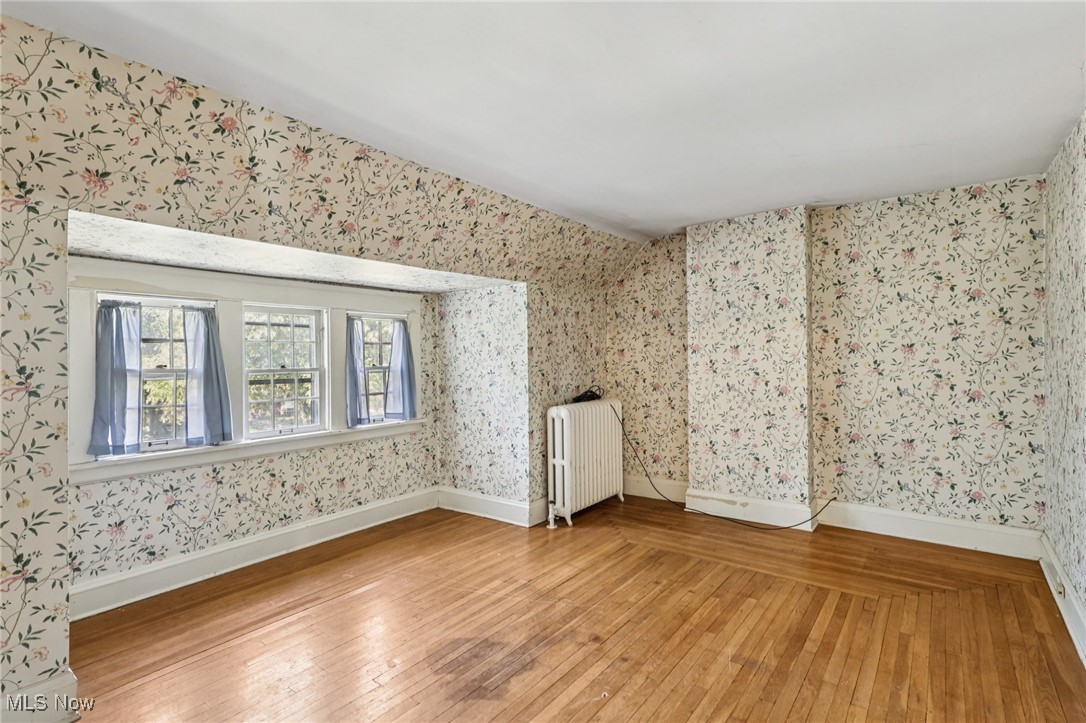 4040 Bayard Road Cleveland, OH 44121 - Photo 32 of 49 Unfurnished room with light wood-style floors, radiator, and wallpapered walls