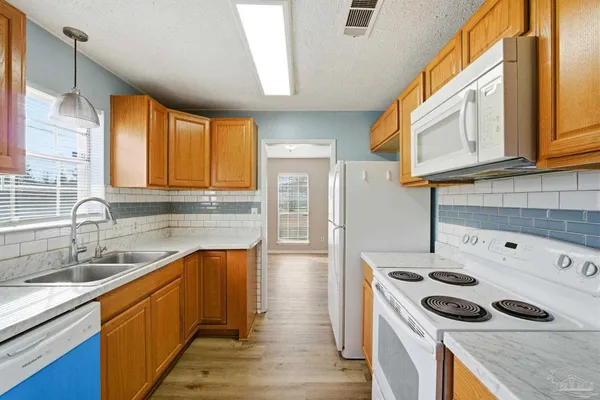 a kitchen with stainless steel appliances granite countertop a sink a stove and a refrigerator