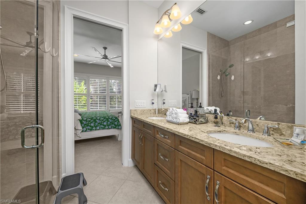 6552 Dominica Drive, Unit 101 Naples, FL 34113 - Photo 17 of 50 a en suite bathroom with a granite countertop sink a toilet and a mirror