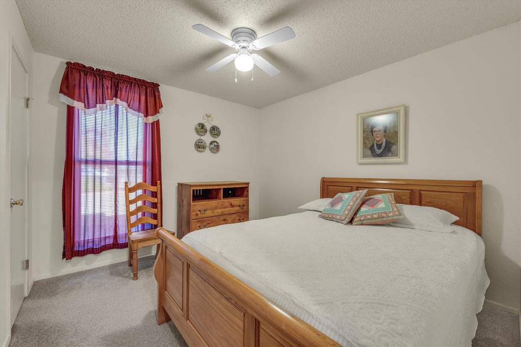 107 Fort Graham Circle Waco, TX 76705 - Photo 19 of 40 Bedroom with light carpet, a textured ceiling, and a ceiling fan