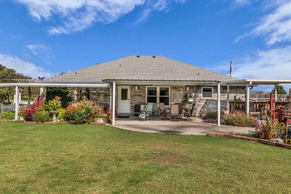 107 Fort Graham Circle Waco, TX 76705 - Photo 24 of 40 Rear view of house featuring roof with shingles, a patio, and brick siding
