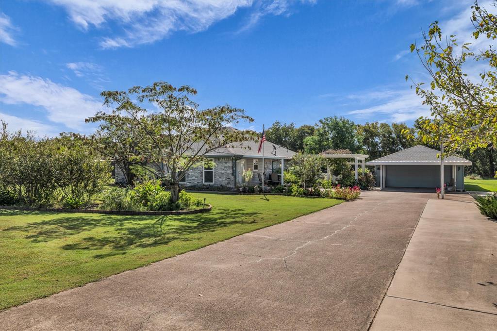 107 Fort Graham Circle Waco, TX 76705 - Photo 3 of 40 Ranch-style home with a front lawn, a garage, concrete driveway, and brick siding