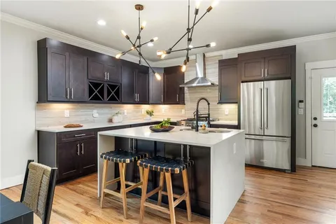 a kitchen with kitchen island granite countertop a wooden floor and white appliances