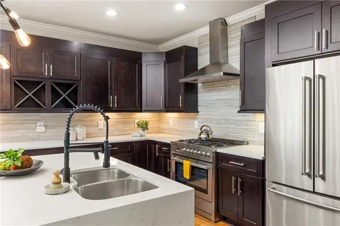 a kitchen with stainless steel appliances a sink a stove and a refrigerator