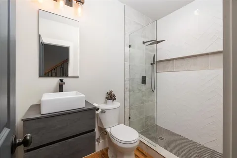 a bathroom with a sink a toilet and shower