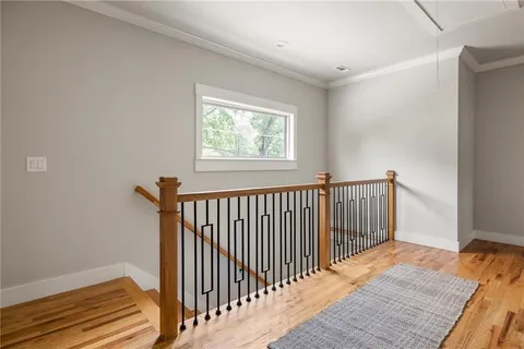 a view of a hallway with wooden floor and a window