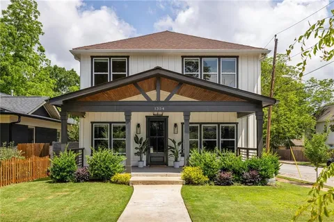 a front view of a house with a yard and potted plants