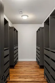 a view of walk in closet with empty racks