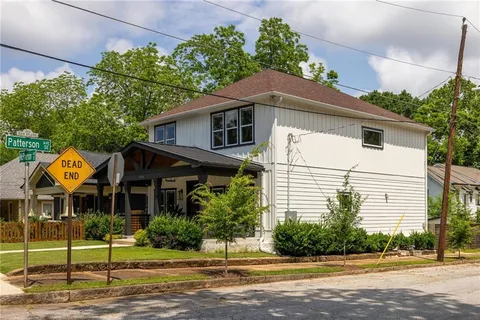 a vase of flowers sitting on a table in front of a house