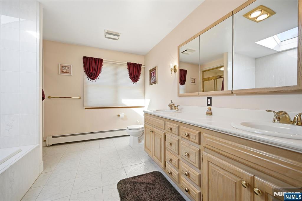 49 Mill Road Park Ridge, NJ 07656 - Photo 15 of 34 a view of a double vanity sink mirror and cabinets