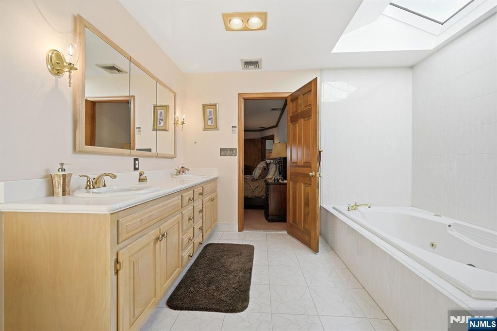 49 Mill Road Park Ridge, NJ 07656 - Photo 16 of 34 a bathroom with a tub sink double vanity and a mirror