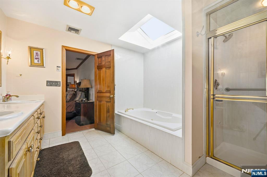 49 Mill Road Park Ridge, NJ 07656 - Photo 17 of 34 a bathroom with a tub a sink and mirrors