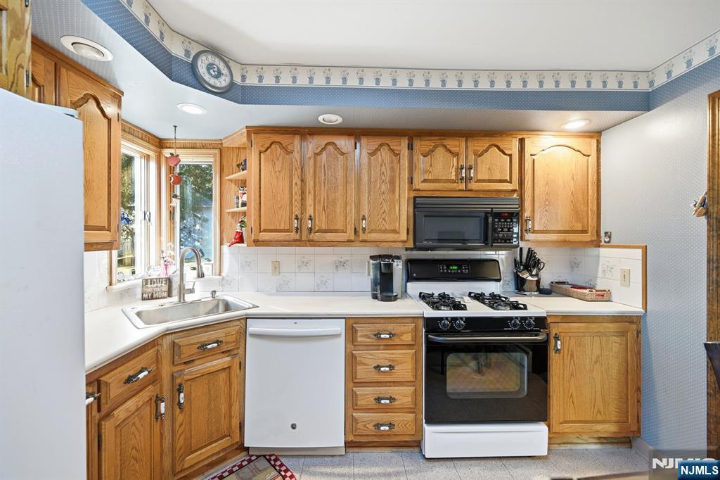 49 Mill Road Park Ridge, NJ 07656 - Photo 9 of 34 a kitchen with stainless steel appliances a stove a sink and a microwave